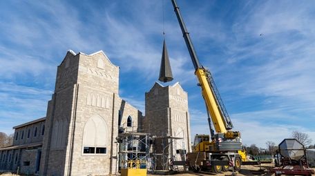 The hoisting and installation of two steeples takes