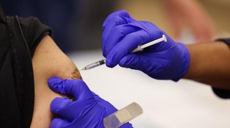 A Pfizer COVID-19 vaccine booster shot is administered