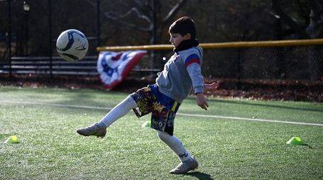 Kirk Kalargiros, 7, of Manhasset, polishes his soccer
