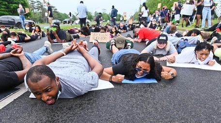 Protesters chant on the ground on Carleton Avenue