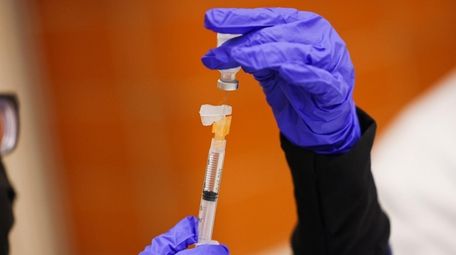 A COVID-19 vaccine booster shot is prepped to