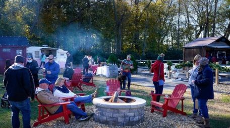 Visitors gather around a fire pit at Santa's