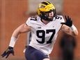 Michigan defensive end Aidan Hutchinson rushes in on