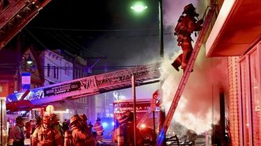 Firefighters battle a fire in a mixed-use building