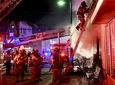 Firefighters battle a fire in a mixed-use building
