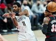 Brooklyn Nets guard Kyrie Irving, left, passes the