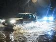 Cars naviage through flooded Granny Road in Medford