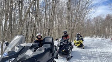 A group heads out on a guided snowmobile