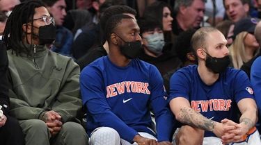 Knicks guard Kemba Walker, center, adjusts a knee
