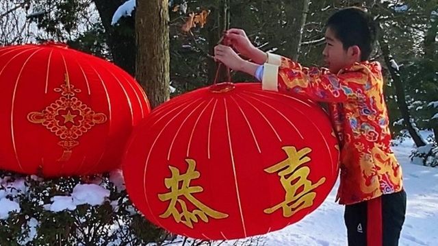 Alexander Zhang helped to hang red lanterns outside