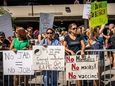 A crowd protests mandates for COVID-19 vaccines and