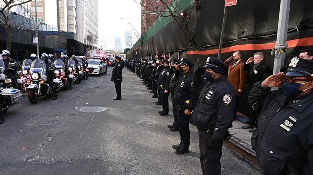 Members of the NYPD salute outside the New