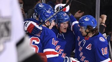 Rangers players celebrate a power-play goal by left