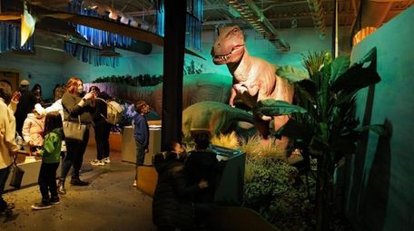 Kids interact with the animatronic dinosaurs at a