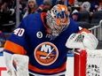 Semyon Varlamov of the Islanders digs the puck