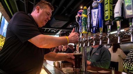 A bartender pours a beer at The Irish