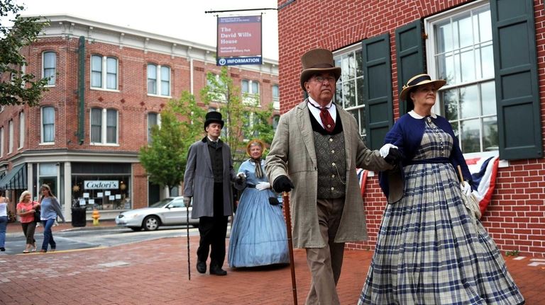 Re-enactors dressed in Civil War period clothing walk