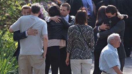 Family and friends console one another outside of