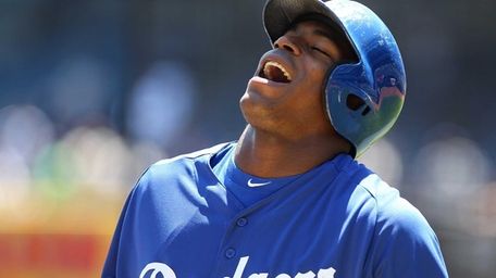 Los Angeles Dodgers right fielder Yasiel Puig laughs