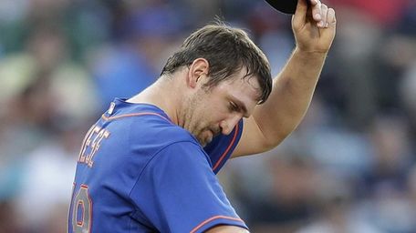 Mets starting pitcher Jonathon Niese wipes his face