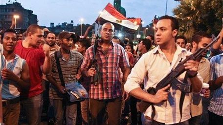 Plainclothes policemen walk with protesters opposed to Egyptian