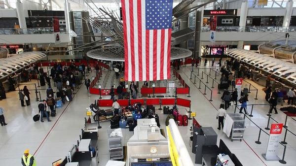 People wait in a security line at John