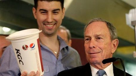 Mayor Michael Bloomberg looks at a 64-ounce soda