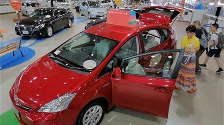 Visitors look at a Toyota Prius hybrid vehicle