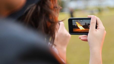 Students take video of the bonfire at John