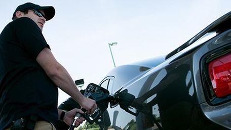 A man fills up his car with gas.