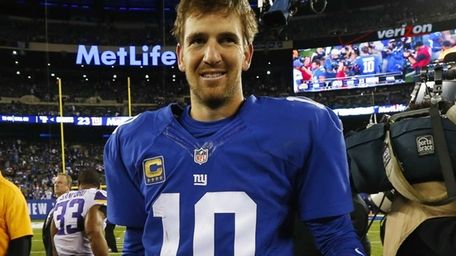 Eli Manning walks off the field after defeating