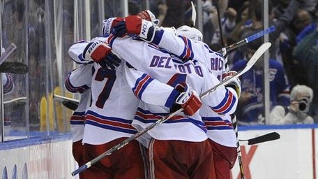 The Rangers celebrate the game-winning goal by Benoit