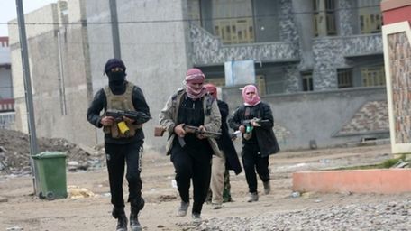 Gunmen patrol during clashes with Iraqi security forces