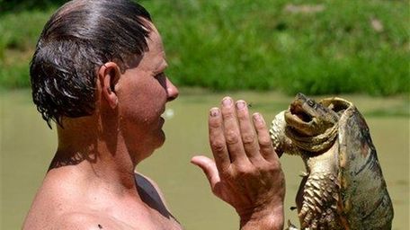 Ernie "Turtleman" Brown holds a snapping turtle he