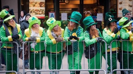 Revelers dressed as leprechauns line the barricades as