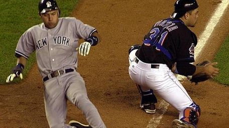 Derek Jeter slides into home as the Mets'