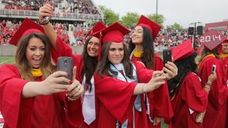 Graduates take selfies during the Stony Brook University