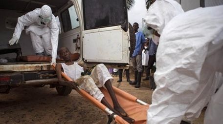 Healthcare workers load a man suspected of suffering