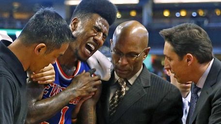 New York Knicks' Iman Shumpert is helped off