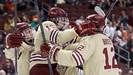 Boston College's Johnny Gaudreau, center, jumps into the