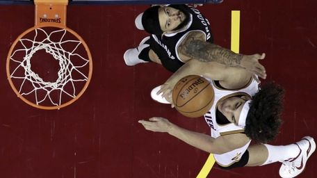 Cleveland Cavaliers' Anderson Varejao, bottom, from Brazil, drives