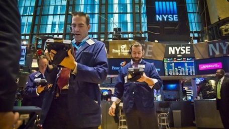 Traders work on the floor of the New