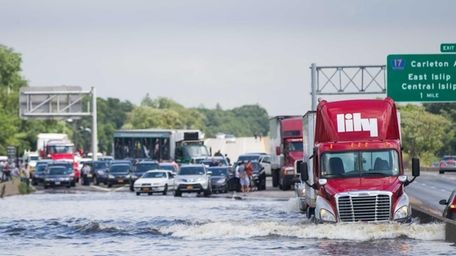 A trailer truck drives through flooded Sunrise Highway